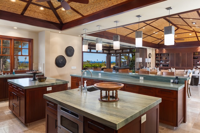 kitchen with ceiling fan, a spacious island, and decorative light fixtures