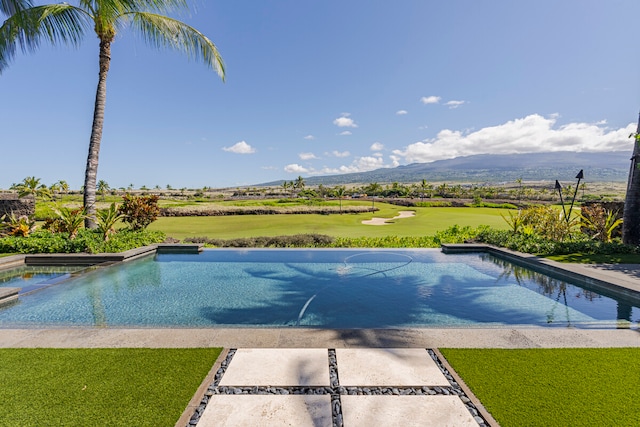 view of pool featuring a patio, a yard, and a mountain view