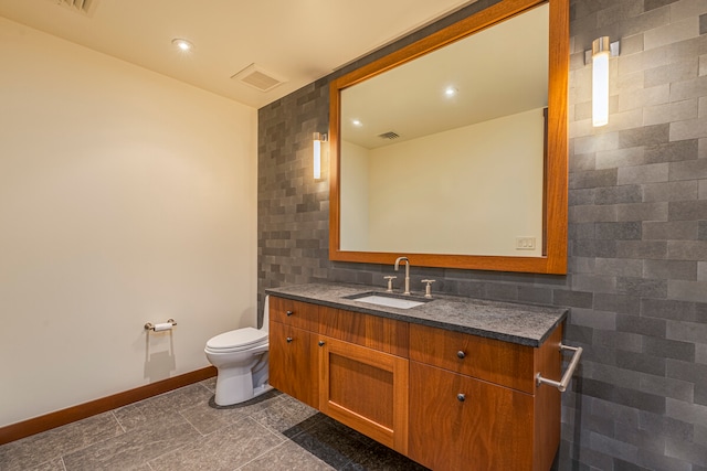 bathroom with tile walls, tile patterned flooring, vanity, and toilet