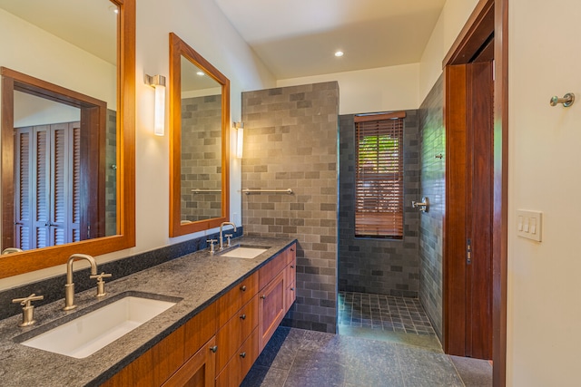 bathroom featuring vanity, tile walls, tile patterned flooring, and a tile shower