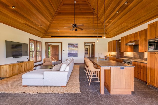 kitchen featuring hanging light fixtures, high vaulted ceiling, wooden ceiling, a kitchen island with sink, and sink