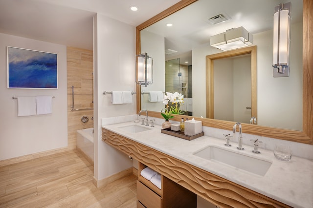 bathroom with hardwood / wood-style floors, vanity, and separate shower and tub