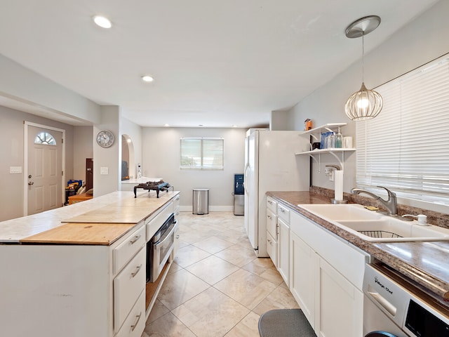 kitchen with oven, washer / clothes dryer, white cabinetry, pendant lighting, and sink