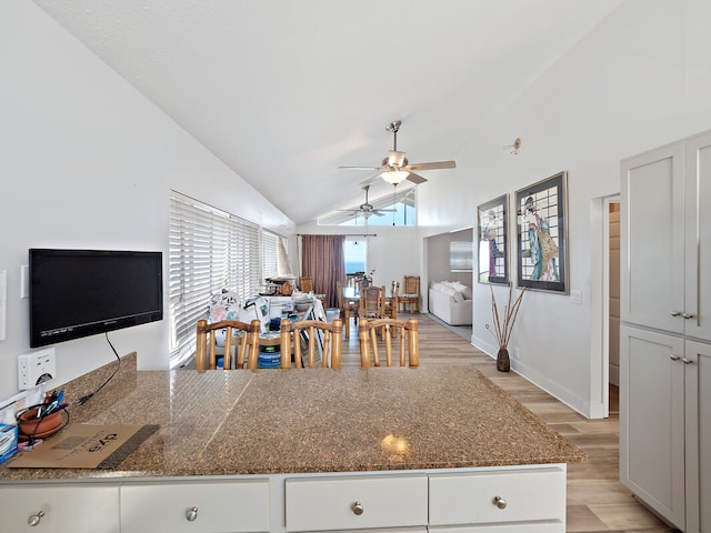 kitchen featuring lofted ceiling, white cabinetry, light hardwood / wood-style floors, and ceiling fan