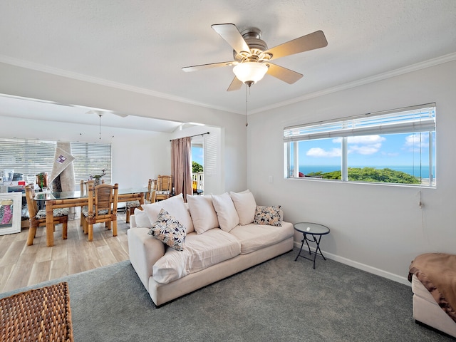 living room featuring crown molding, wood-type flooring, and ceiling fan