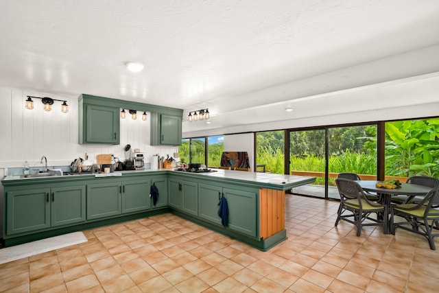 kitchen with kitchen peninsula, green cabinets, and a healthy amount of sunlight