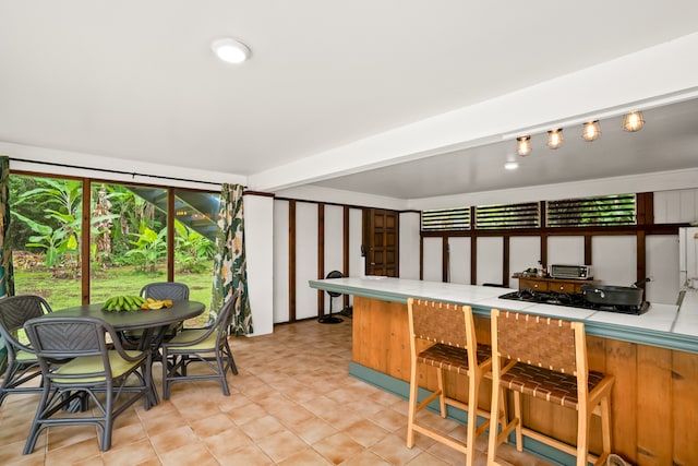 kitchen featuring black gas stovetop, tile counters, and rail lighting