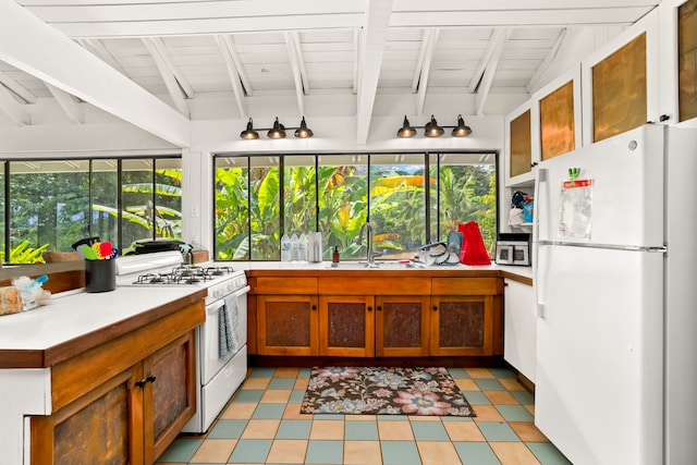 kitchen featuring white appliances, wood ceiling, lofted ceiling with beams, and sink