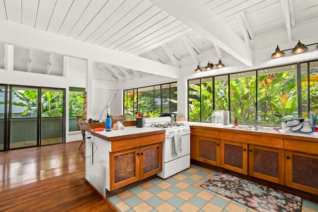 kitchen with vaulted ceiling with beams, wood ceiling, light hardwood / wood-style flooring, sink, and white range with gas stovetop