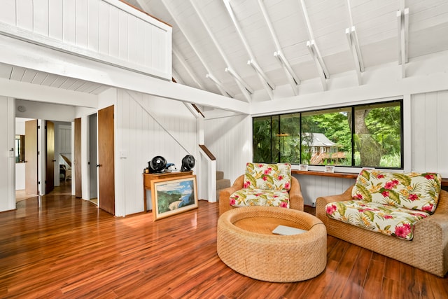 living room featuring hardwood / wood-style floors, lofted ceiling with beams, and wood walls