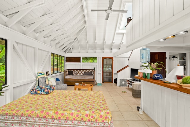 interior space with wood walls, vaulted ceiling with skylight, and light tile patterned floors