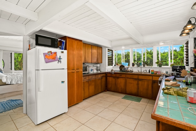 kitchen with beam ceiling, light tile patterned flooring, wooden ceiling, and white refrigerator