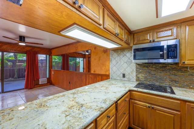 kitchen featuring black cooktop, plenty of natural light, light tile patterned floors, and decorative backsplash