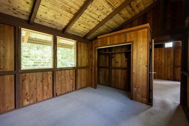 interior space featuring light carpet, wooden walls, lofted ceiling with beams, and wood ceiling