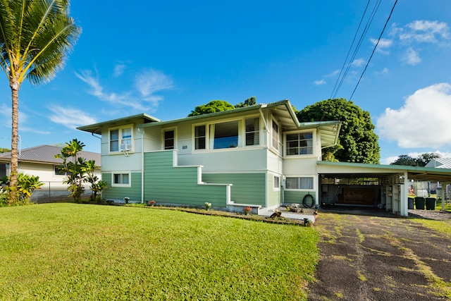 view of front of house with a carport, a balcony, and a front lawn