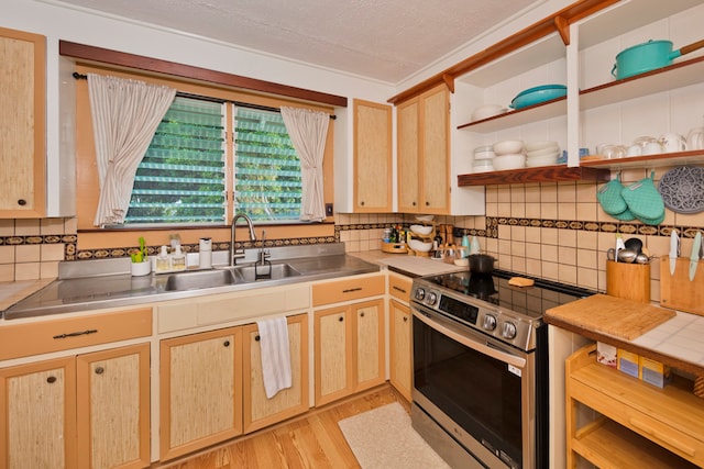 kitchen featuring stainless steel range, a textured ceiling, sink, and light brown cabinetry