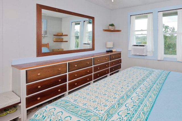 bedroom featuring cooling unit and wooden walls