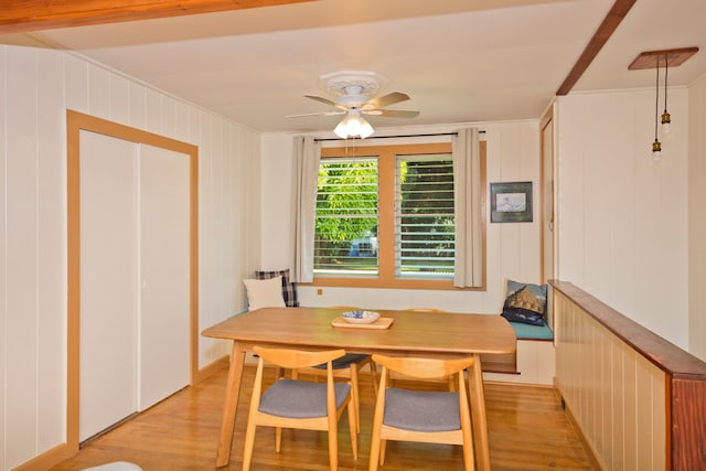 dining area featuring wood walls, light hardwood / wood-style floors, and ceiling fan