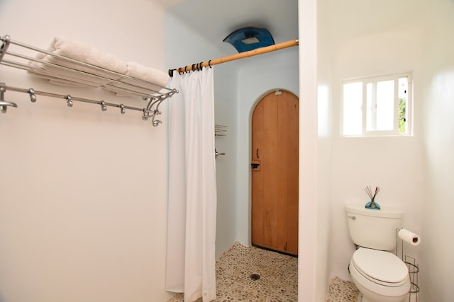 bathroom with toilet and curtained shower