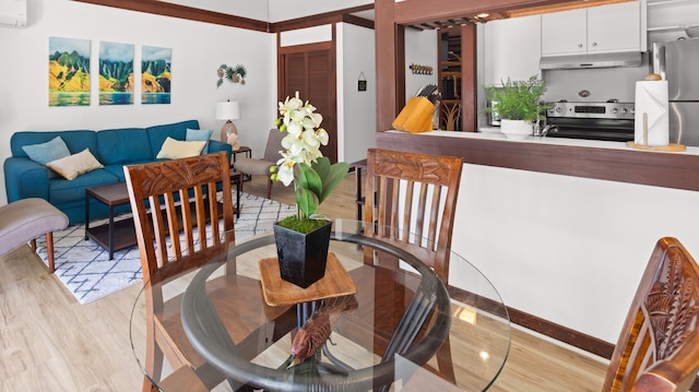 dining area featuring an AC wall unit and light wood-type flooring