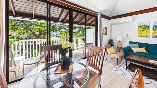sunroom with a wall mounted AC, wood finished floors, and lofted ceiling