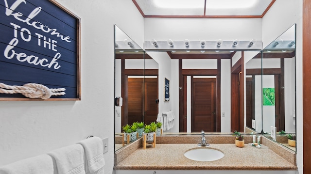 bathroom with crown molding and vanity