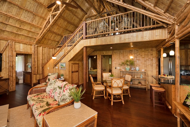 living room featuring wooden walls, dark hardwood / wood-style floors, high vaulted ceiling, and wooden ceiling