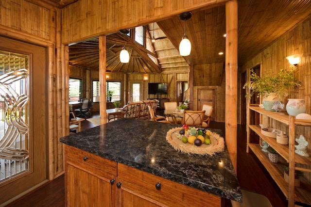 kitchen with wood ceiling, hanging light fixtures, lofted ceiling, wooden walls, and dark hardwood / wood-style flooring