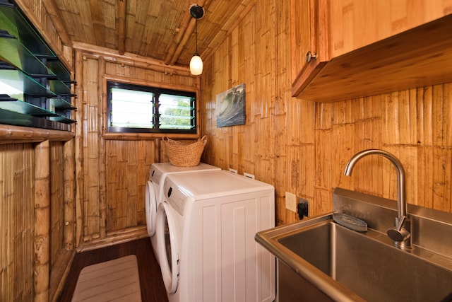 washroom featuring wood ceiling, wood walls, sink, cabinets, and washer and dryer