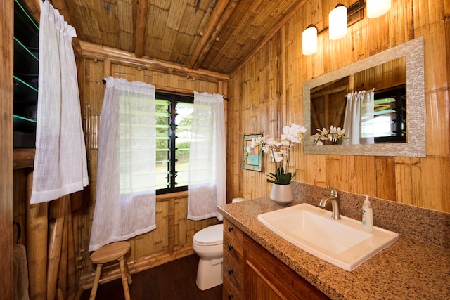 bathroom with wooden walls, vanity, wood-type flooring, wood ceiling, and toilet