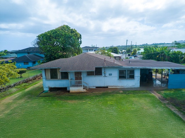 back of house featuring a yard and a carport