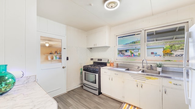 kitchen featuring sink, white cabinetry, stainless steel gas range, and light wood-type flooring