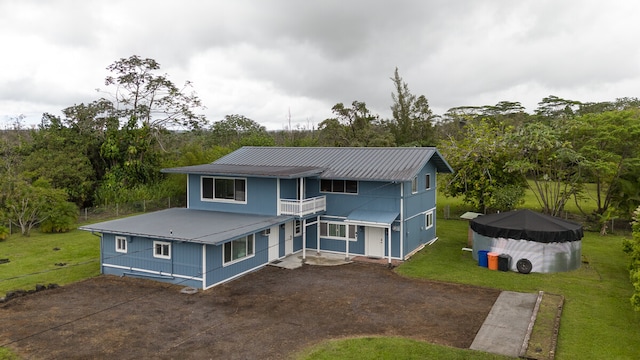 view of front of home with a balcony and a front lawn