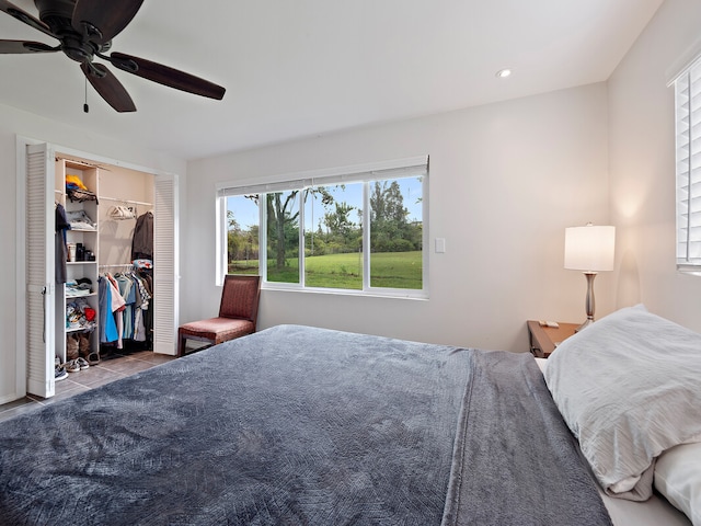 tiled bedroom with a spacious closet, a closet, and ceiling fan