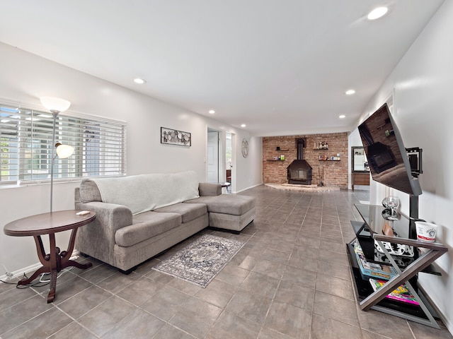 living room with tile patterned floors, a wood stove, and brick wall