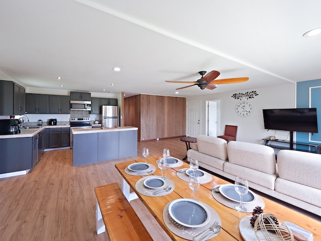 dining room featuring light hardwood / wood-style flooring, ceiling fan, and sink