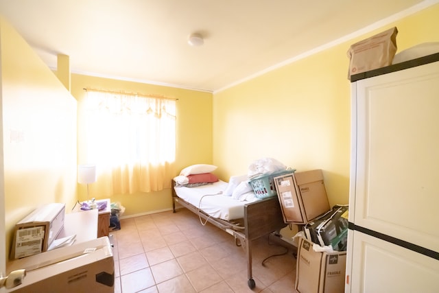 bedroom with ornamental molding and light tile patterned floors