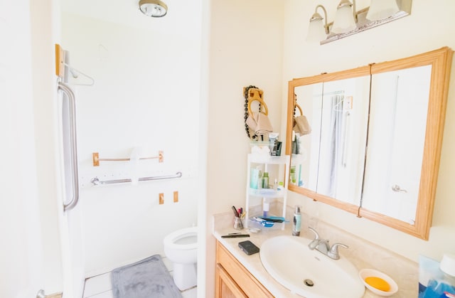 bathroom with vanity, tile patterned flooring, and toilet