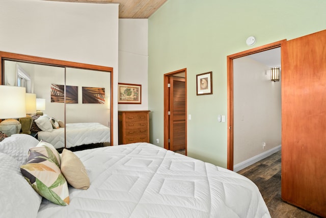 bedroom with dark hardwood / wood-style floors, high vaulted ceiling, a closet, and wood ceiling