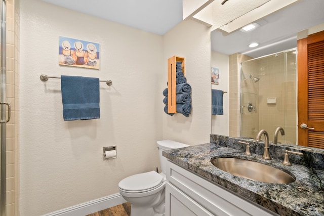 bathroom with vanity, toilet, a shower with door, and hardwood / wood-style flooring