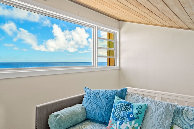 sitting room with a water view, wooden ceiling, and a view of the beach