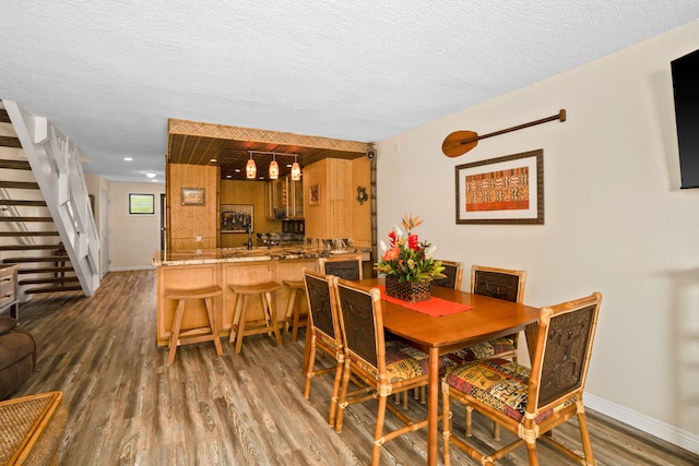 dining space featuring dark hardwood / wood-style flooring and a textured ceiling