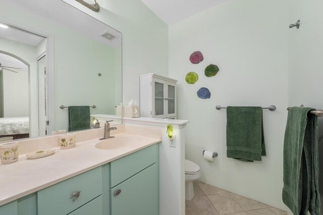 bathroom with tile patterned floors, vanity, ceiling fan, and toilet