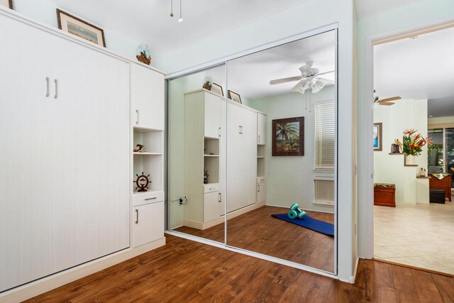 interior space featuring ceiling fan, dark hardwood / wood-style flooring, and a closet