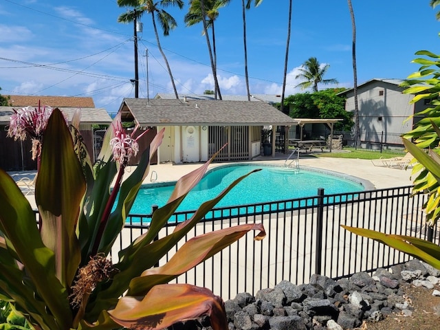 view of swimming pool with a patio and an outbuilding