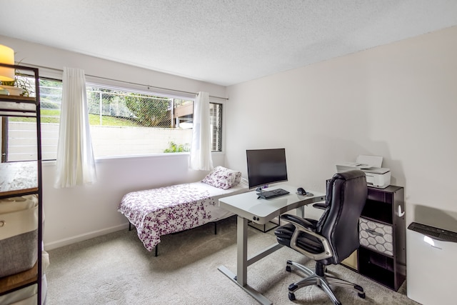 carpeted home office featuring a textured ceiling