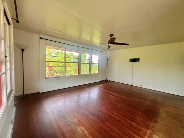 empty room featuring dark wood-type flooring and ceiling fan