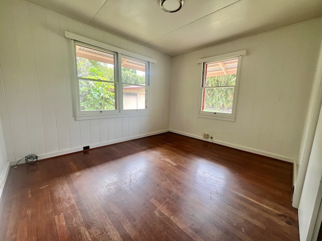 unfurnished room featuring dark hardwood / wood-style flooring and plenty of natural light