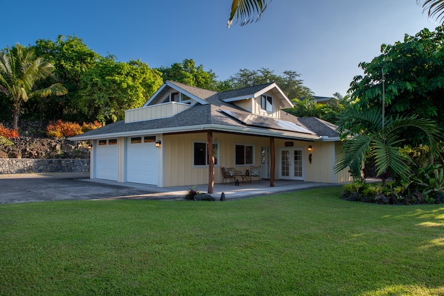 view of front facade featuring french doors, a garage, and a front lawn