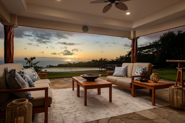 exterior space featuring a water view, an outdoor living space, and ceiling fan